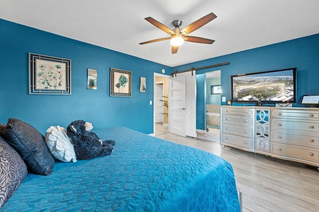 1404 E Mission Rd, Fallbrook, CA 92028 - bedroom with a barn door, wood finished floors, ensuite bath, and ceiling fan
