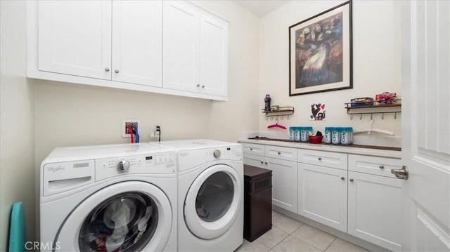 laundry area with independent washer and dryer, cabinets, and light tile patterned floors