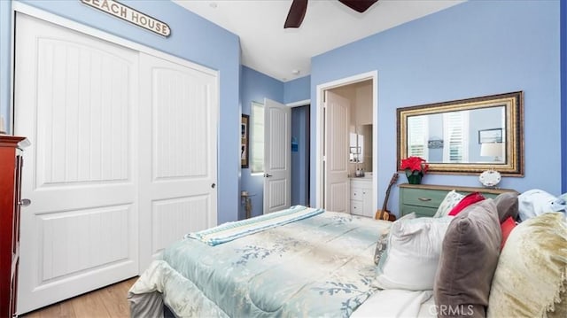 bedroom featuring ceiling fan, light hardwood / wood-style floors, a closet, and ensuite bath