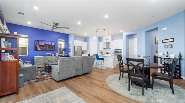 living room featuring ceiling fan and light hardwood / wood-style floors