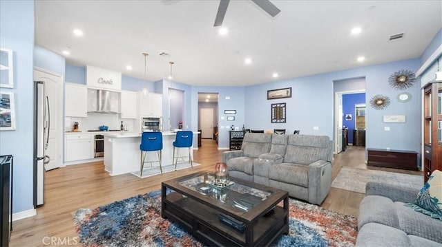 living room featuring light wood-type flooring and ceiling fan