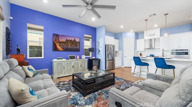 living room with ceiling fan and light hardwood / wood-style floors