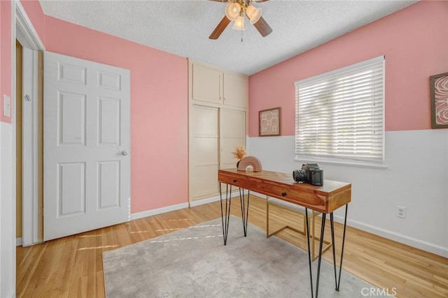 office area featuring a textured ceiling, ceiling fan, and light hardwood / wood-style floors