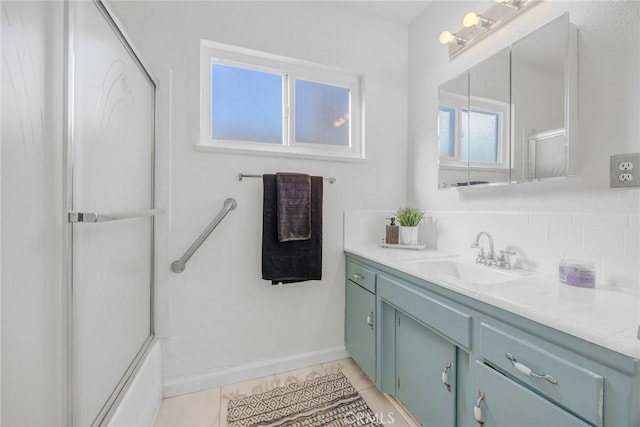 bathroom with bath / shower combo with glass door, tile patterned flooring, and vanity