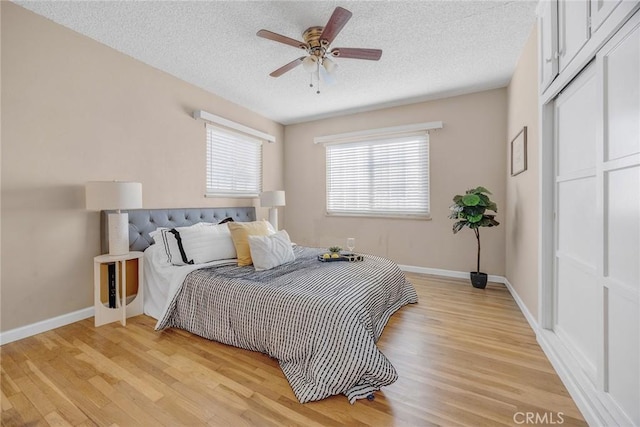 bedroom featuring a textured ceiling, ceiling fan, and light hardwood / wood-style flooring