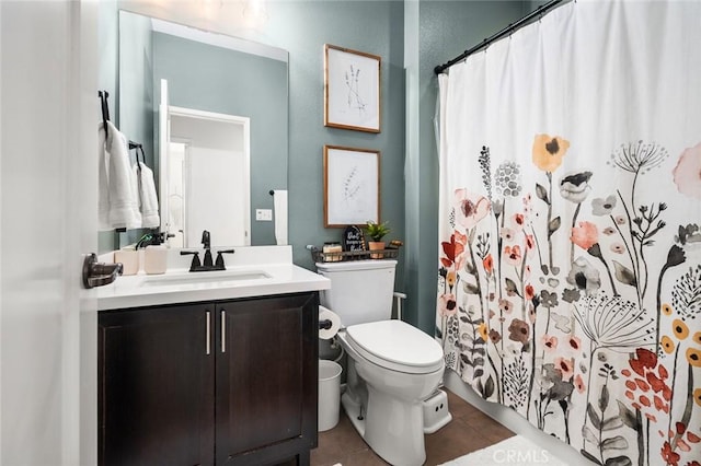 bathroom with toilet, vanity, tile patterned floors, and walk in shower