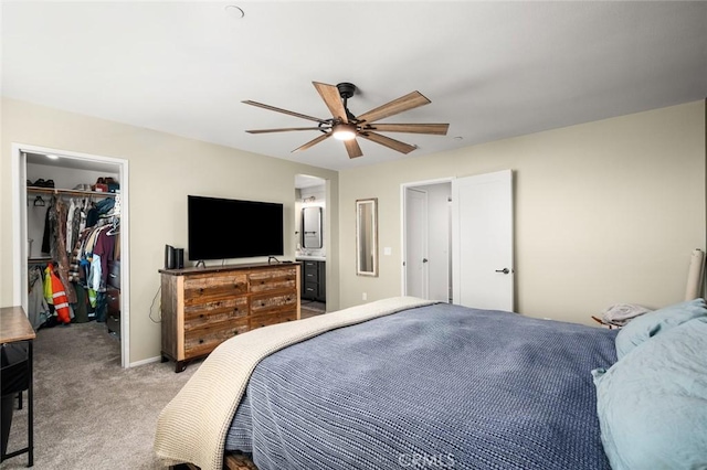 carpeted bedroom with ceiling fan, connected bathroom, a closet, and a walk in closet