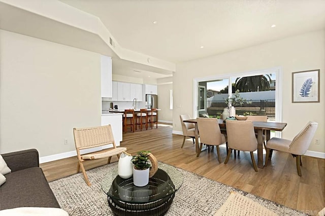 living room featuring sink and light hardwood / wood-style flooring