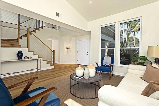 living room with wood-type flooring and high vaulted ceiling