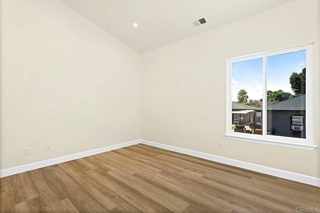 empty room featuring hardwood / wood-style floors and lofted ceiling