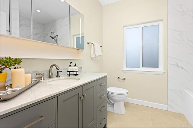 bathroom featuring a tile shower, vanity, and toilet