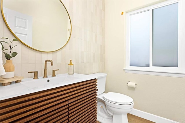 bathroom with hardwood / wood-style flooring, vanity, and toilet