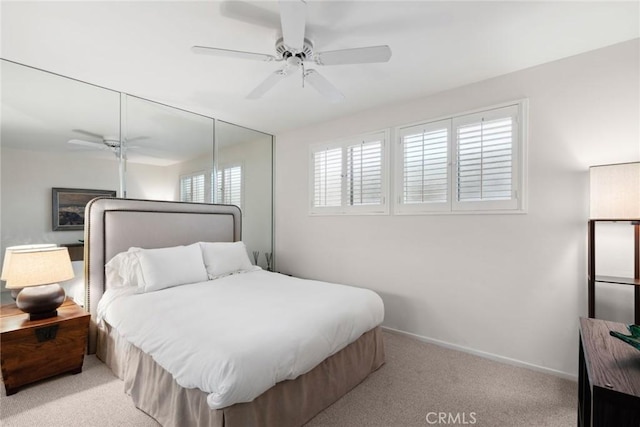 carpeted bedroom featuring a closet, a ceiling fan, and baseboards