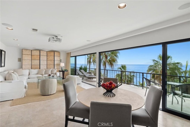 dining space with recessed lighting, a water view, and light tile patterned floors