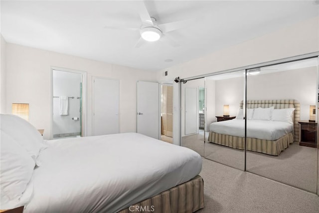 carpeted bedroom with ceiling fan, a closet, and ensuite bathroom