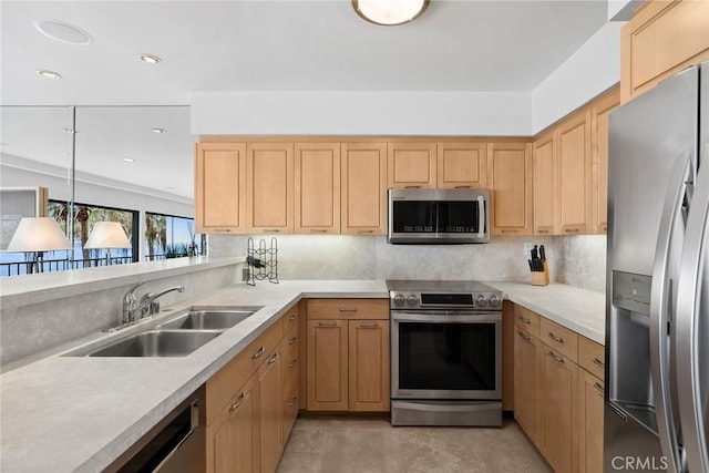 kitchen featuring stainless steel appliances, a sink, light countertops, light brown cabinetry, and tasteful backsplash