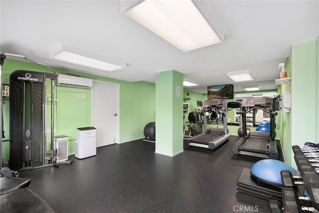 gym with baseboards and a wall mounted AC