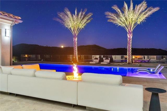 pool at night featuring an outdoor living space