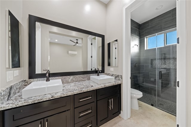 bathroom with ceiling fan, a shower with door, vanity, and toilet