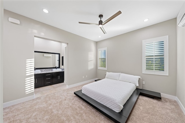 carpeted bedroom with ceiling fan, ensuite bathroom, and sink