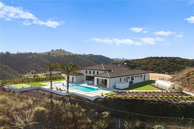 view of pool with a mountain view, a yard, and a patio area