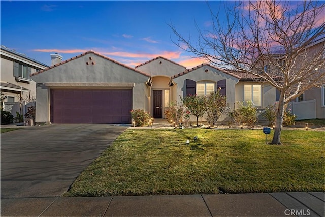 mediterranean / spanish-style home with a garage and a yard