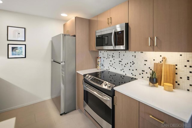 kitchen with backsplash, light tile patterned floors, and stainless steel appliances