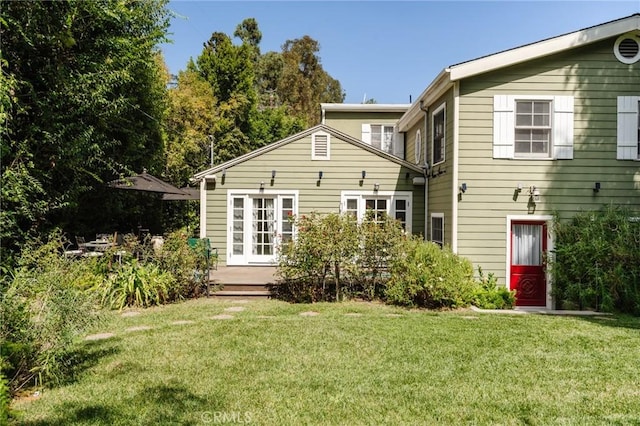 rear view of property featuring french doors and a yard