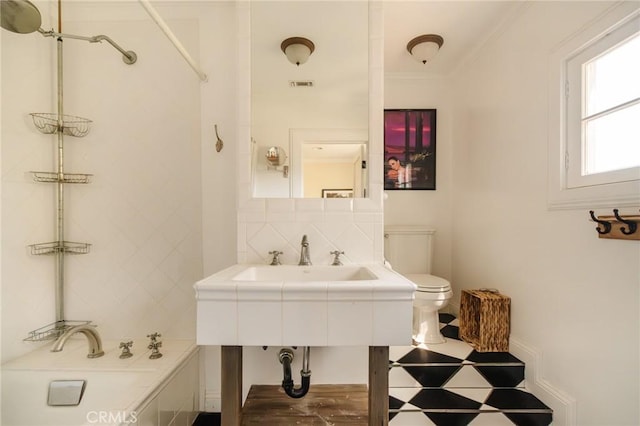 bathroom with decorative backsplash, toilet, and a washtub