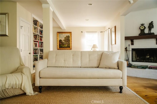 sitting room with a brick fireplace and hardwood / wood-style flooring