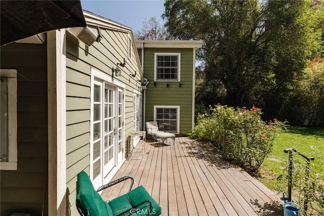 wooden deck featuring a lawn and french doors