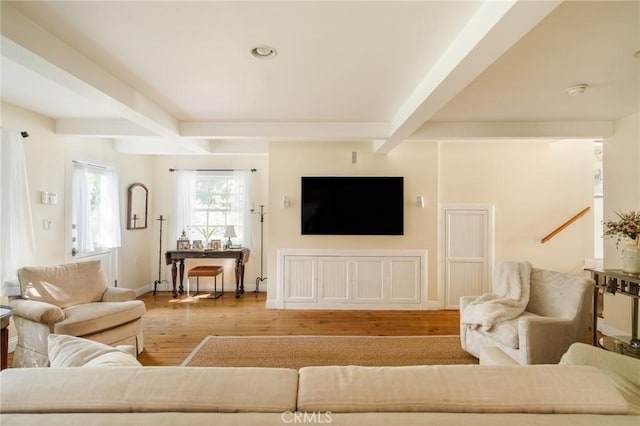 living room featuring beam ceiling and hardwood / wood-style floors