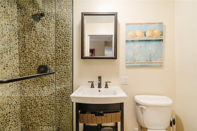 bathroom with vanity, toilet, and a shower with door