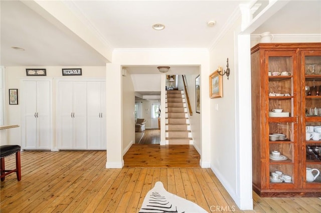 entrance foyer with light hardwood / wood-style floors and ornamental molding