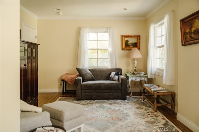 sitting room with hardwood / wood-style floors and ornamental molding