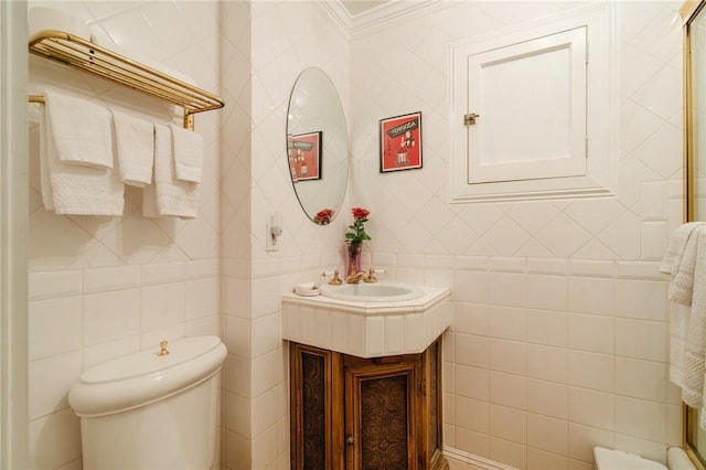 bathroom featuring vanity, toilet, tile walls, and ornamental molding