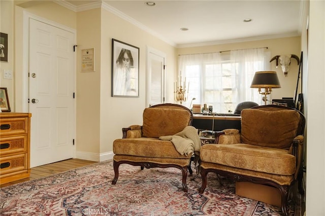 sitting room with hardwood / wood-style floors and ornamental molding