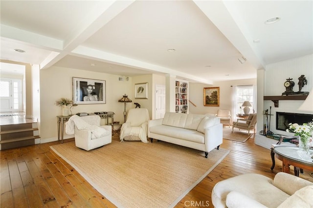 living room with beamed ceiling and light wood-type flooring