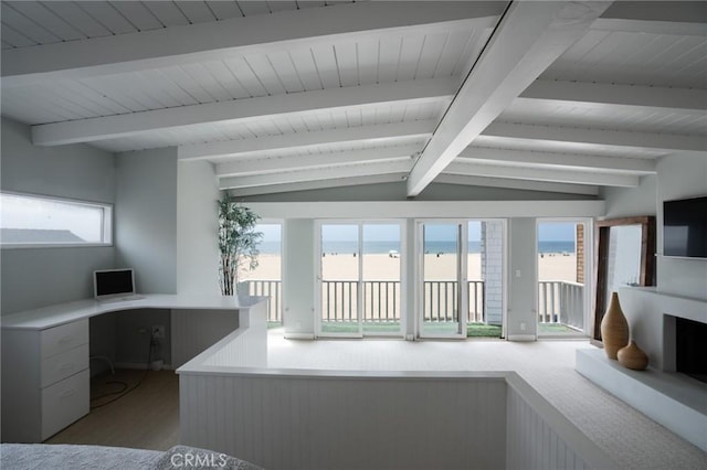 living room featuring built in desk and vaulted ceiling with beams