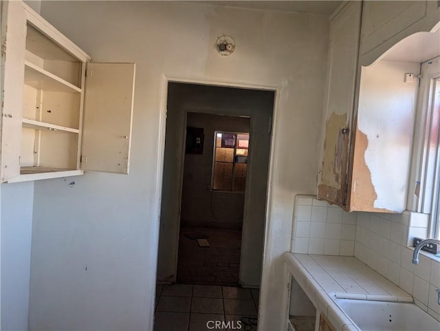 bathroom featuring sink, backsplash, and tile patterned flooring