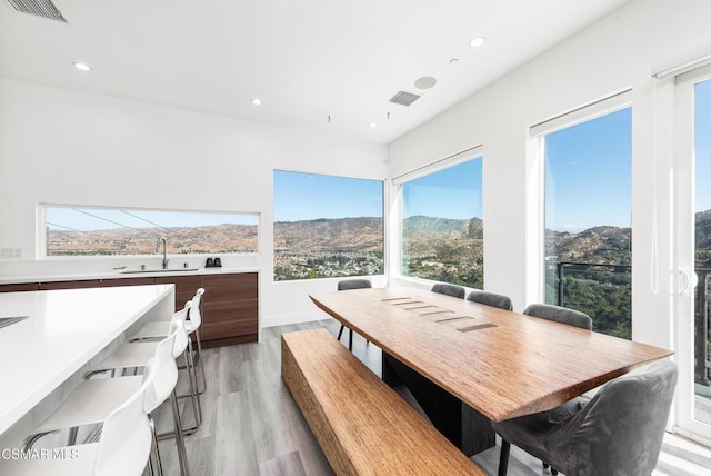 dining room featuring a mountain view, light wood-type flooring, and sink