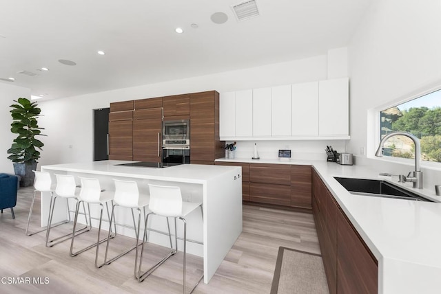 kitchen featuring sink, white cabinets, a kitchen island, and appliances with stainless steel finishes