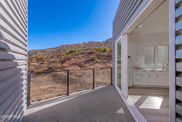 balcony featuring a mountain view and sink