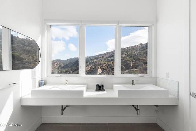 bathroom featuring tile patterned floors, a mountain view, and dual sinks