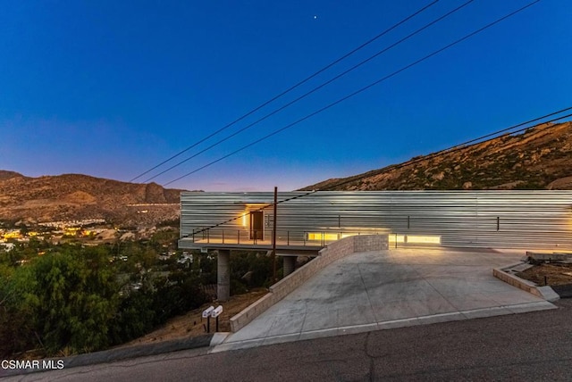 property exterior at dusk featuring a mountain view