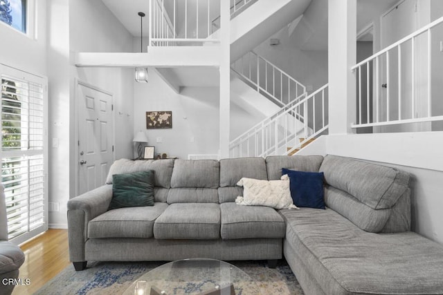 living room with hardwood / wood-style flooring and a towering ceiling