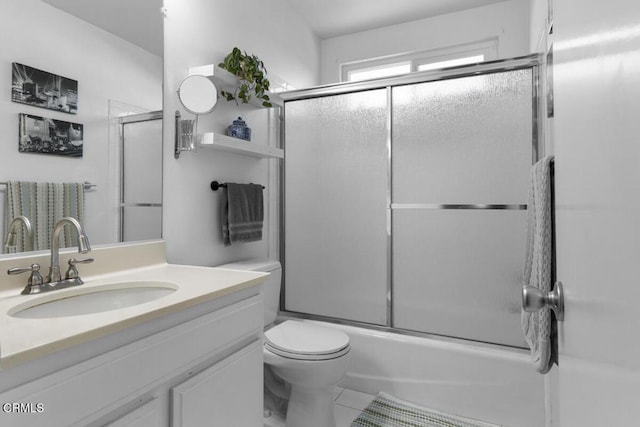 bathroom with enclosed tub / shower combo, vanity, toilet, and tile patterned floors