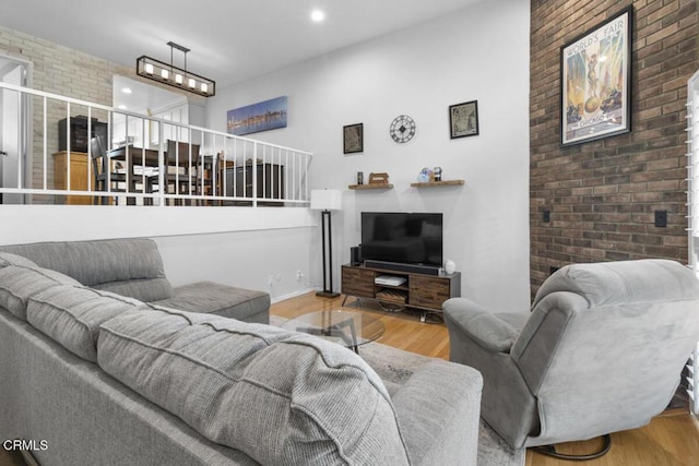 living room featuring brick wall, wood finished floors, and recessed lighting