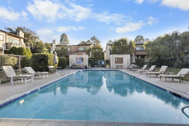 pool featuring fence and a patio