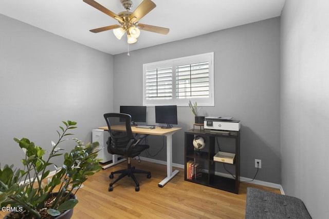 office space with light wood-type flooring, baseboards, and a ceiling fan